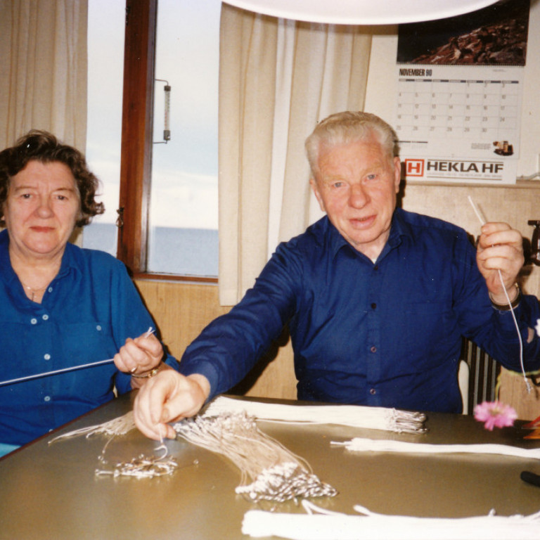 Sveinlaug Friðriksdóttir og Þorsteinn Eyfjörð í Vallholti að hnýta á öngla við eldhúsborðið