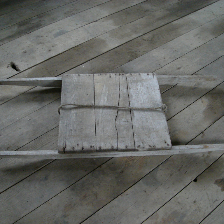 Handbörur. Saltfiskbörur.
Þegar saltfiskurinn var þurrkaður var hann tekinn úr stakknum og staflað á svona börur sem tveir báru á milli sín til að dreifa honum um fjöruna. Best var að breiða fiskinn þar sem gróf möl var í fjörunni og enginn sandur. Mölin var alltaf hrein, sjórinn sá um það. Til að nýta plássið var fiskinum raðað vandlega. Honum var snúið um miðjan dag ef þurrkur hélst. Ef fór að rigna þurfti hraðar hendur að taka saman og stakka. Þá var hlaðið eins og komst á börurnar og hlaupið með þær.